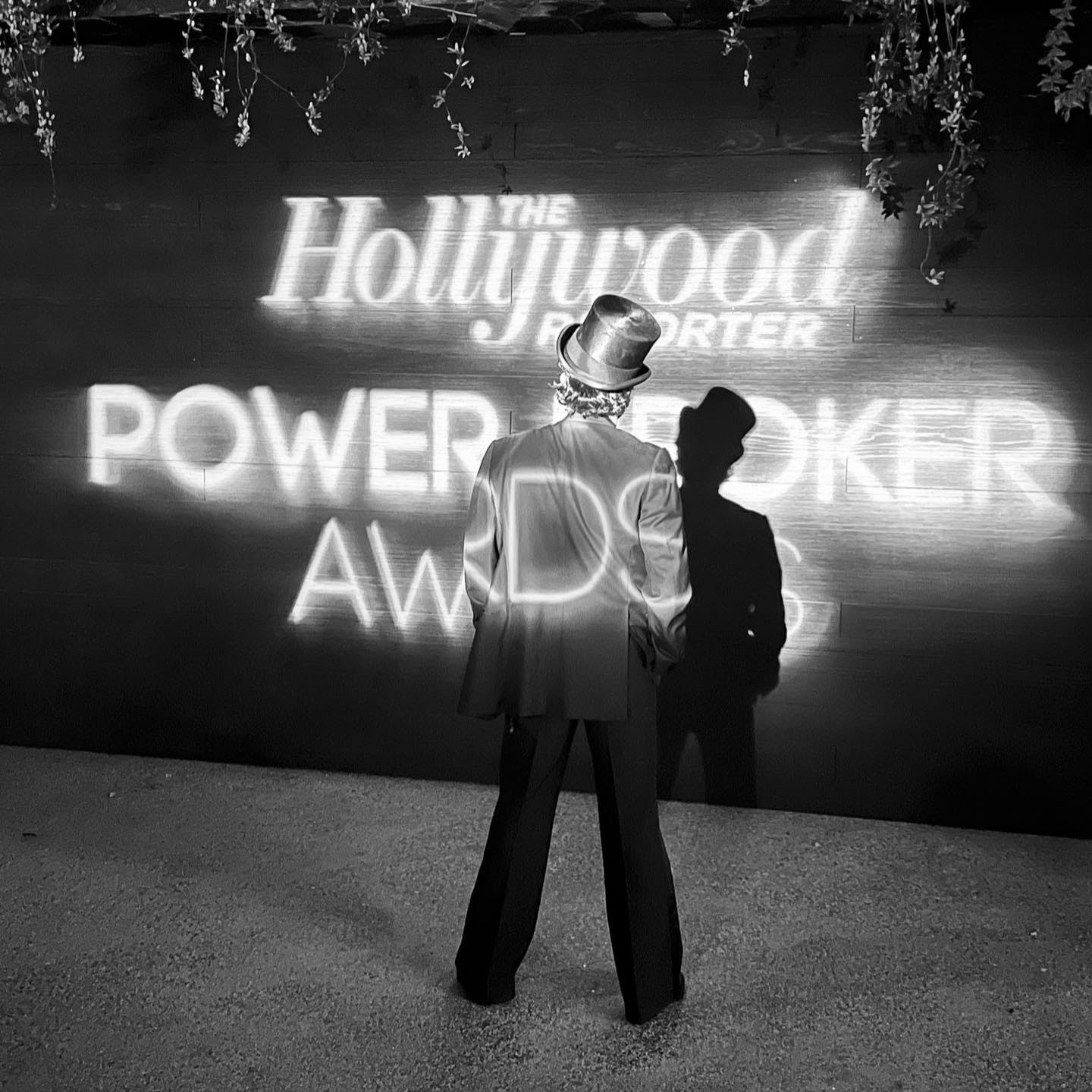 Guest before The Hollywood Reporter Power Broker Awards projection wall.
